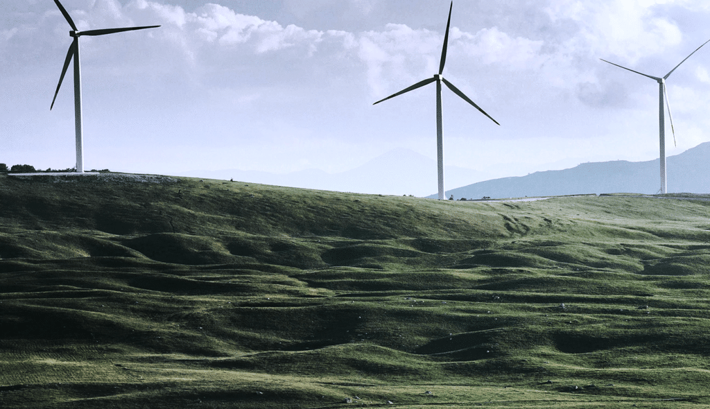 wind turbines in a green valley with clouds