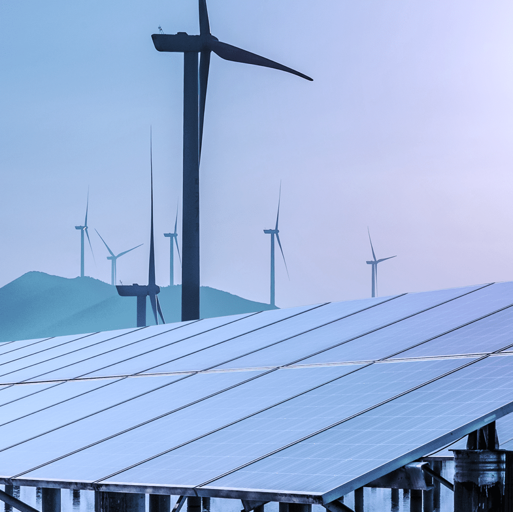 Solar panels and wind turbiens with a mountain in the back