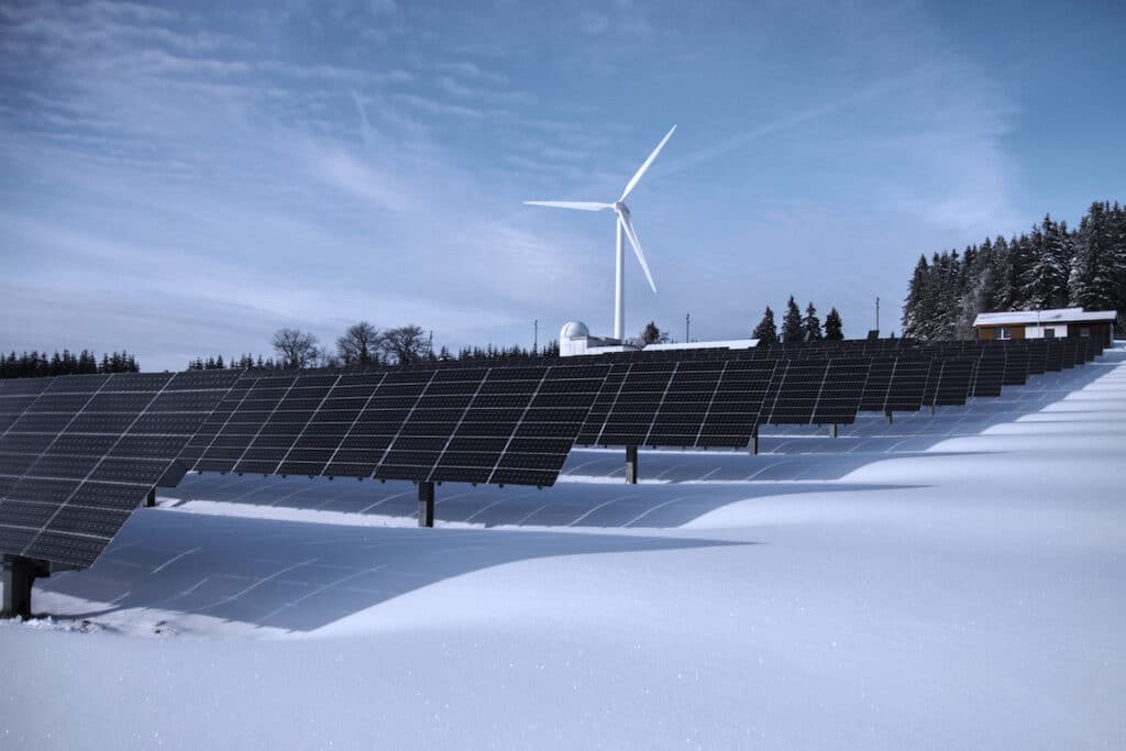 Wind turbines with solar panels in a snowy field