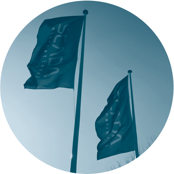 SCADA International flags waving in the wind with a blue sky (circle format)