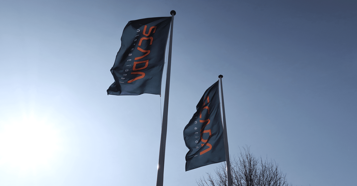 SCADA International flags waving in the wind with a blue sky