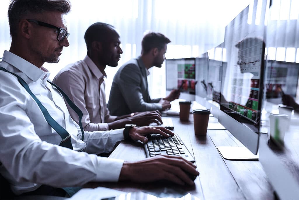 men within the energy trading market sitting with monitors.